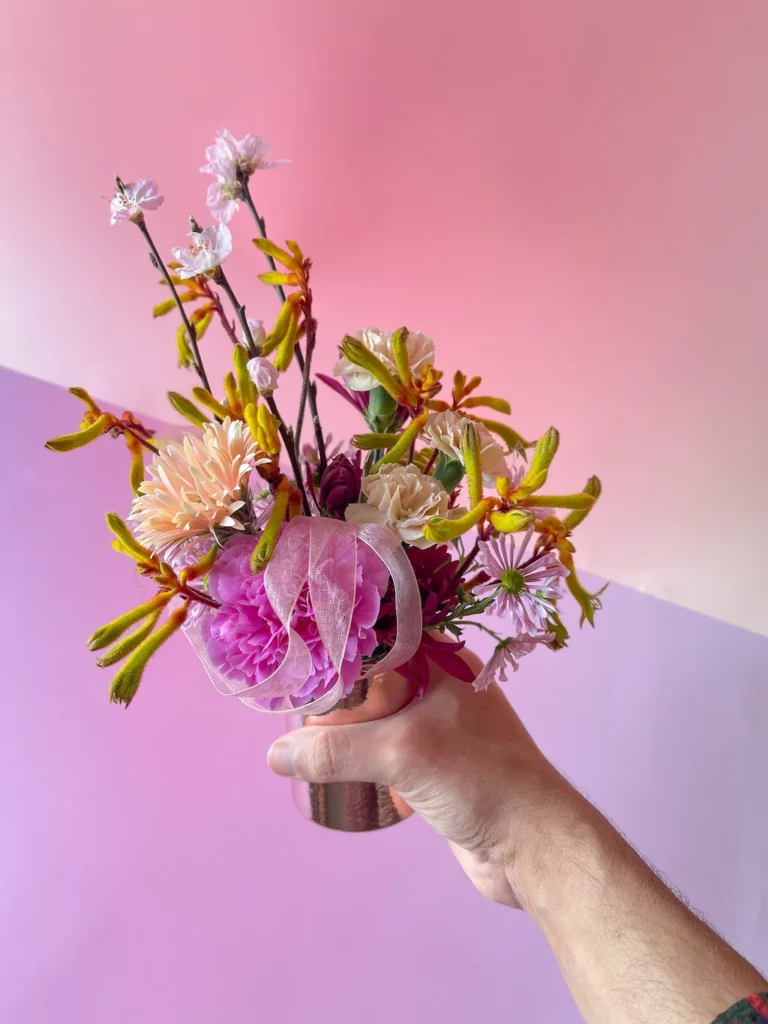 Arranjo floral em caixa bronze visto de cima, composição artística Sabiá Porto