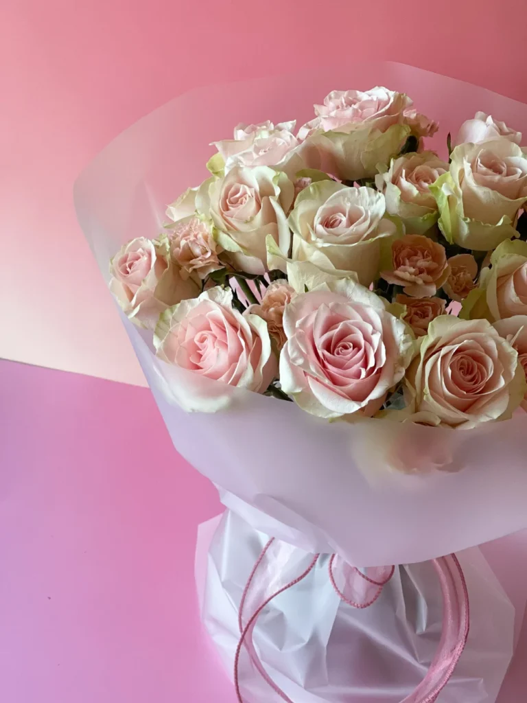 Composição artística do bouquet Rose Embrace com rosas em tons pêssego e champanhe